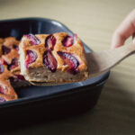 ruka která zvedá kousek ovocného koláče